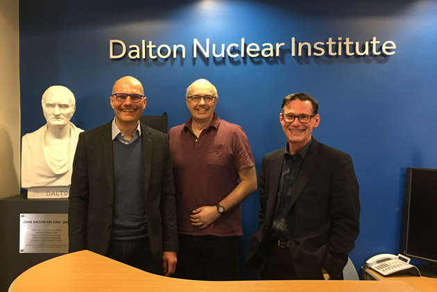 Three ex-Directors of the Dalton Nuclear Institute standing together in the office reception area beside the bust of John Dalton